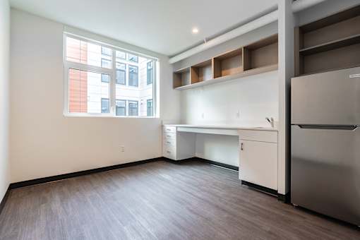 A kitchen with a refrigerator, sink, and window.