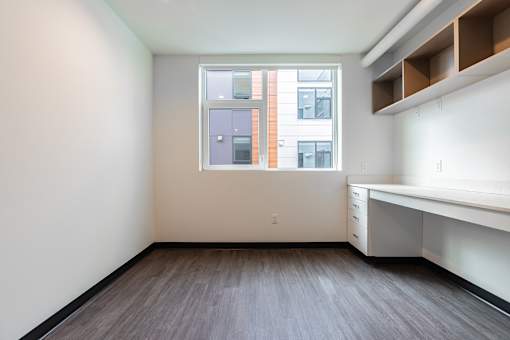 A room with a window and a desk.
