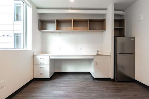 A kitchen with a desk and drawers.