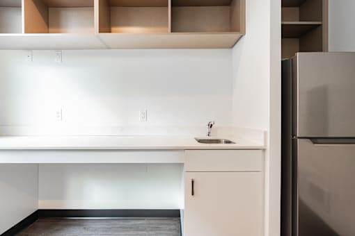 A kitchen with a sink and a refrigerator.