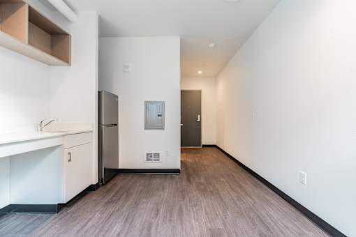 A kitchen with white cabinets and a refrigerator.