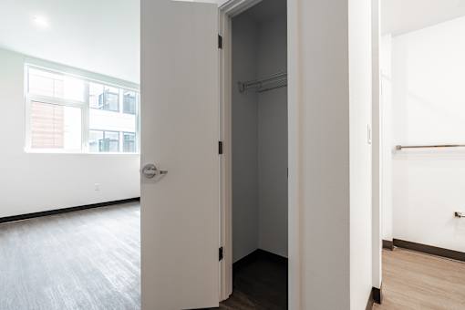 A white door is open to a dark room.