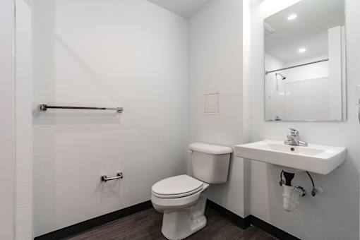 A white toilet and sink in a small bathroom.