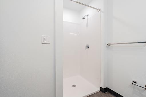 A white bathroom with a walk in shower.