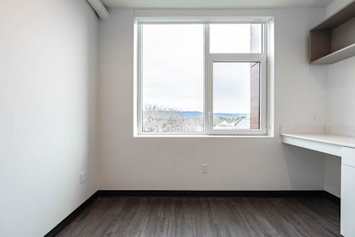 A room with a large window and a desk.