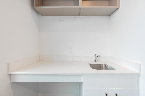 A white sink is in a white countertop.