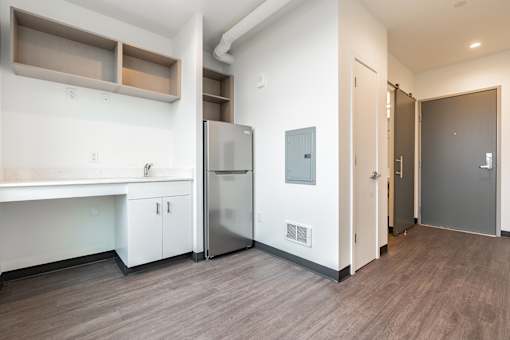A kitchen with a refrigerator and a counter.