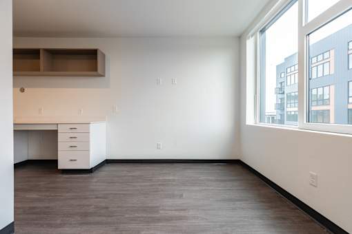 A room with a desk and drawers in it.