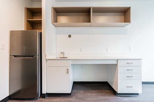 A kitchen with a white desk and drawers.