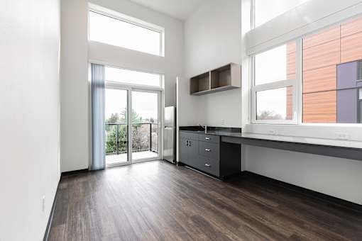 A kitchen with a wooden floor and white walls.