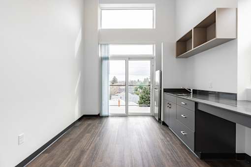 A kitchen with a view of a construction site outside.