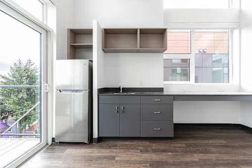 A modern kitchen with a refrigerator, cabinets, and a countertop.