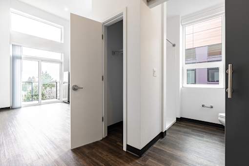 A white door is open to a room with a window.