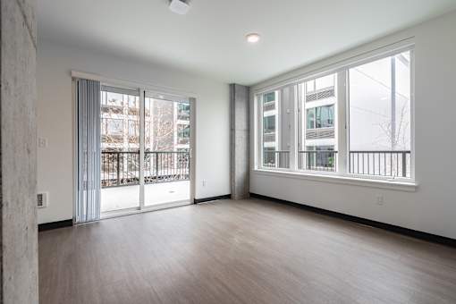 A large empty room with a window and a door.