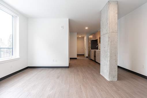 A room with a large window and a concrete pillar.