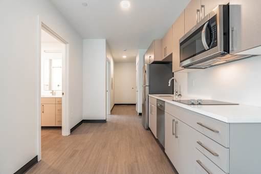 A kitchen with a microwave oven mounted above the stove.