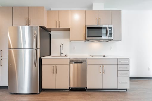 A modern kitchen with a stainless steel refrigerator and microwave.