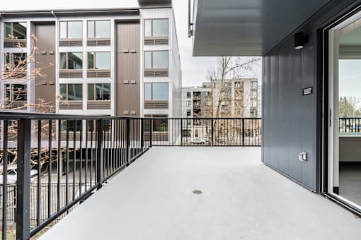 A modern building with a balcony and a black railing.