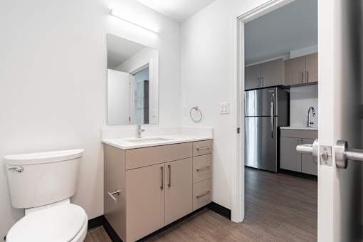 A bathroom with a toilet, sink, and mirror.