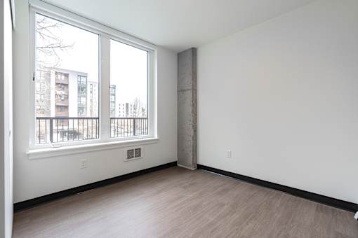 A room with a large window and a view of a building outside.