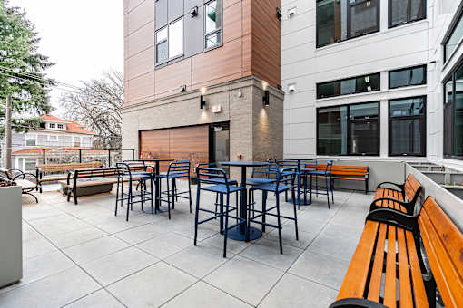 A patio with a table and chairs is surrounded by benches.