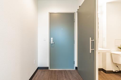 A bathroom with a blue door and a white sink.