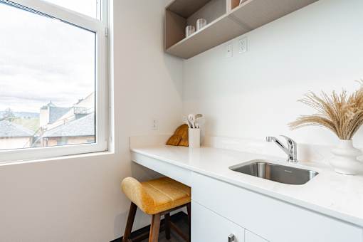 A kitchen with a white counter and a window.