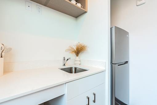 A kitchen with a sink and a refrigerator.