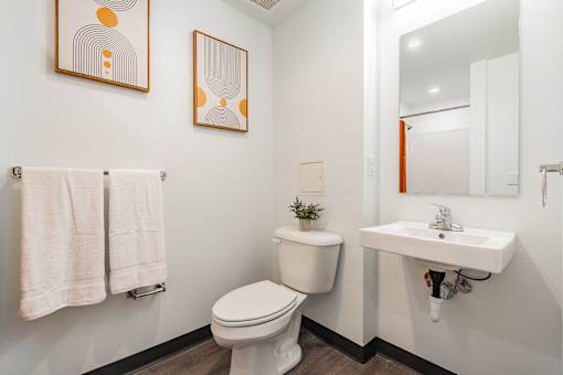 A white toilet sits next to a white sink in a bathroom.