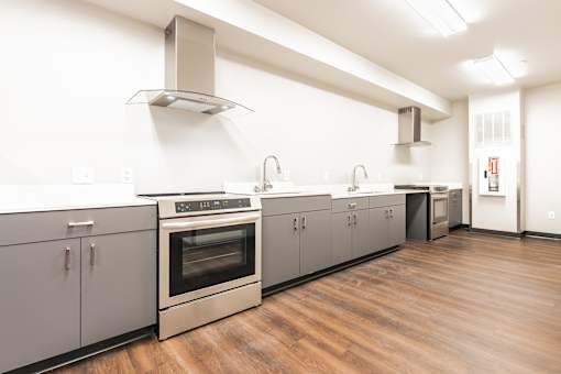 A modern kitchen with wooden floors and stainless steel appliances.