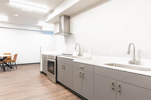 A modern kitchen with a wooden floor and white walls.