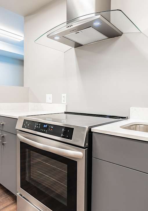 A modern kitchen with a stainless steel oven and range hood.