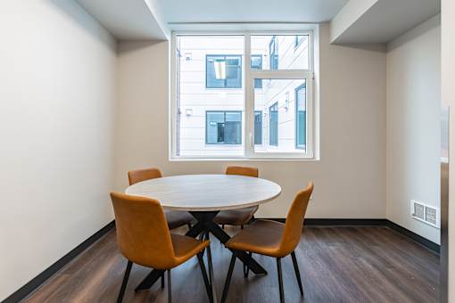 A conference room with a table and four chairs.