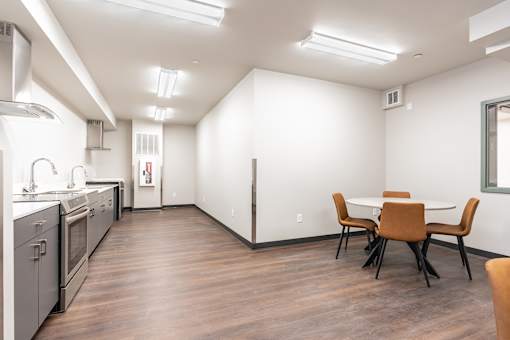 A kitchen with a table and chairs in the middle of the room.