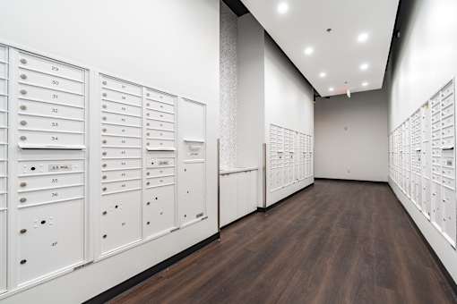 A long hallway with white lockers on the wall.