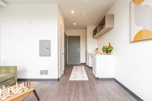 A hallway with a chess board on the coffee table.