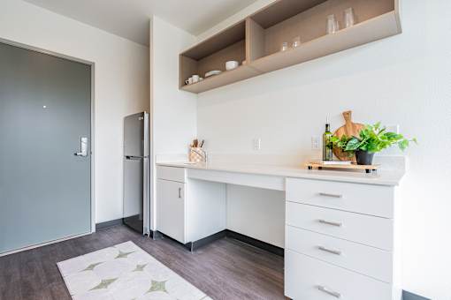 A kitchen with a white countertop and a refrigerator.
