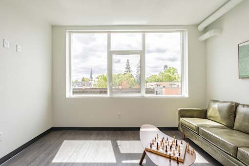 A room with a couch, a table and a chess board on it.