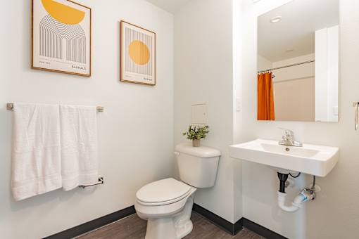 A white toilet sits in a bathroom next to a white sink.