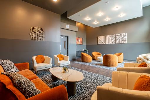 A room with orange and white chairs and a black coffee table.