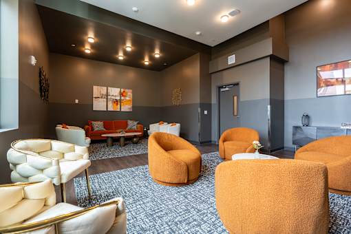A room with orange chairs and a white couch.