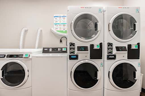 A row of washing machines with the number 35 on the front of the second one from the right.