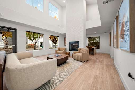 A modern living room with a large window and a fireplace.