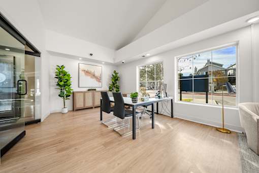 A modern home office with a desk, chair, and a large window.