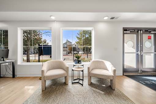 Two chairs and a table are in a room with a glass door.