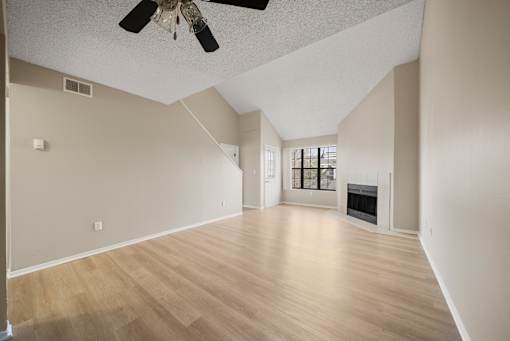 A room with a fireplace and a ceiling fan.