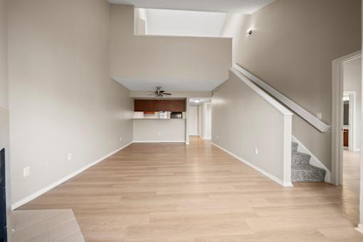 A spacious room with wooden flooring and a skylight.