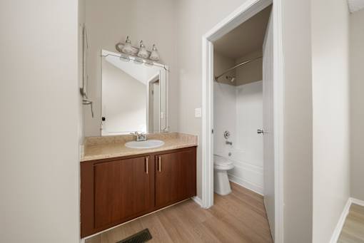 A bathroom with a sink, mirror, and toilet.