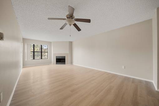 A room with a ceiling fan and wooden flooring.