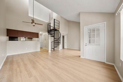 A room with a spiral staircase and a ceiling fan.
